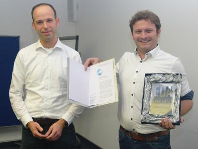 v.l.n.r.: Laudator Dr. Jan-Hendrik Oetjens von der Robert Bosch GmbH übereicht stellvertretend für das edacentrum den EDA Achievement Award 2019 an Dr. rer. nat. Alexander Viehl vom FZI Forschungszentrum Informatik