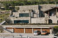 Naturstein aus der Region prägt das terrassiert im Hang liegende private Wohnhaus mit Blick auf das Tal / Bildnachweis: Andrea Puliogotto