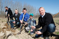 gemeinsamer erster Spatenstich: Michel Anders (8) pflanzt mitWEMAG-Vorstand und Landwirtschaftsminister Backhaus die ersten Setzlinge.