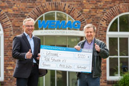 WEMACOM-Mitarbeiter Thomas Pätzold (li.) hat über die Crowdfunding-Plattform der WEMAG Spenden eingesammelt, die er nun dem Vorsitzenden der Schweriner Tafel, Peter Grosch, symbolisch überreichen konnte (Foto: WEMAG/Stephan Rudolph-Kramer)