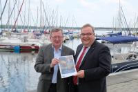 Der Vorsitzende des Tourismusausschusses der IHK Magdeburg Detlef Dahms (l.) und Michael Pirl, Vorsitzender des Tourismusausschusses der IHK Halle-Dessau mit dem Freizeitbarometer 2018 an der Marina/Goitzsche / Quelle: IHK Halle-Dessau/Michael Deutsch 