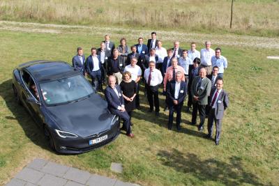 Teilnehmer des dritten Energiesymposiums mit Elektrotestfahrzeug. Vorne links: Professor Jean-Marie Bemtgen und Gabriele Seitz, vorne rechts: Organisator und Moderator Johannes Schmidt (EurA Consult). (Foto: EurA Consult)