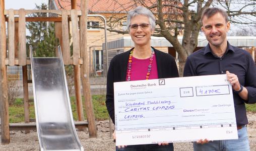 Hendrik Franz, CFO, DeskCenter Solutions, bei der Schecküberreichung an Gabriele Fleck-Hartmuth, Leiterin des Kinder- und Jugenddorfs Markkleeberg