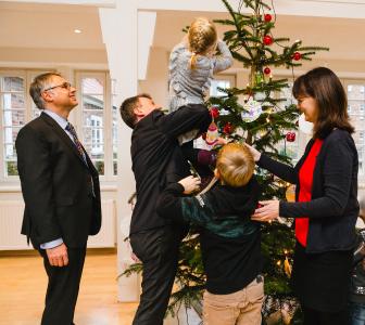 Thomas Murche, technischer Vorstand der WEMAG und Caspar Baumgart, kaufmännischer Vorstand der WEMAG, schmücken mit Kindern und Silke Schönrock vom Demmlerhaus (v.l.) den Weihnachtsbaum mit Wünschen, Foto: WEMAG/Anne Jüngling