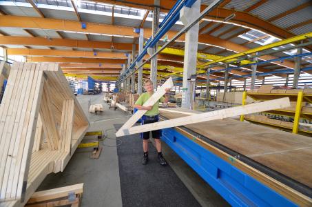 Bianca Bäker ist gelernte Bautischlerin und arbeitet seit über elf Jahren in der Produktion bei Opitz Holzbau in Neuruppin. Bei der Herstellung von Nagelplattenbindern ist der routinierte Umgang mit Maschinentechnik für sie geübte Praxis. Foto: Achim Zielke für OPITZ Holzbau/GIN, Ostfildern; www.nagelplatten.de