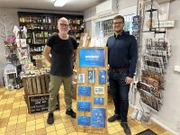 Marktleiter Martin Liebknecht und WEMAG-Mitarbeiter Danilo Schlag (v.l.) bestücken den Aufsteller für den Dorfladen in Retgendorf mit Informationsmaterial für Strom- und Erdgaskunden