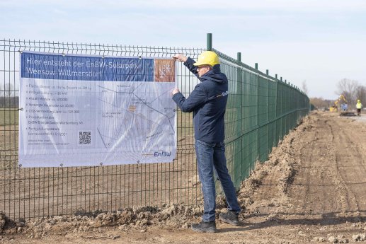 EnBW Mitarbeiter Michael Matthes befestigt das Bauschild vor Ort_KLE_5237 a.jpg