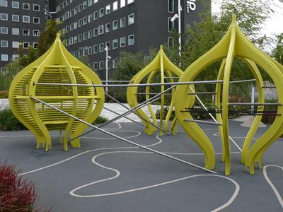 Wie Kunstobjekte wirken die gelben Klettergerüste des Spielbereichs auf dem Dach.