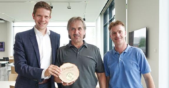 Piepenbrocker David Jung übergibt das goldene Siegel für die 100. Ökologische Gebäudereinigung an Stephan Reißenweber und Jens Baumann, Brose Gruppe (v. l.) / Bild: Piepenbrock