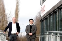 Mimaki Deutschland Geschäftsführer Hisashi Takeuchi übergibt Textildrucker TS300P-1800 als Leihgabe an Fogra-Institutsleiter Dr. Eduard Neufeld im Rahmen des Forschungsprojekts „TextileRGB“. (Bild: Fogra)