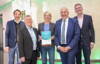 Preisverleihung des Josef-Grünbeck-Preises 2025: (von links) Dirk Lambach (AGP), Jürgen Weißenburger (Kuratoriumsvorsitzender Loni und Josef Grünbeck-Stiftung), Claudia Henke (Platform Coops eG) mit der Urkunde, Dr. Günter Stoll (Grünbeck AG) und Prof. Dr. Thomas Steger (AGP) bei der feierlichen Übergabe in Höchstädt