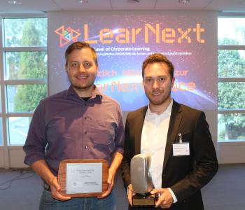 Christian Steiner (senselab.io) und Oswin Breidenbach (TÜV SÜD Akademie GmbH) (v.l.n.r.) nehmen den Immersive Learning Award entgegen