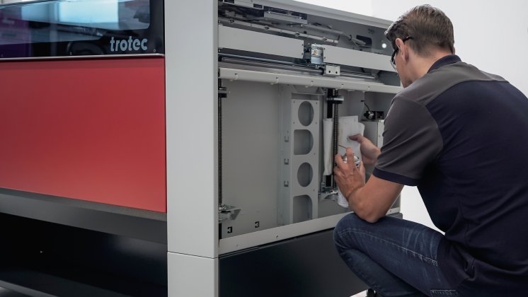 Technician performing maintenance on Trotec laser system.jpg