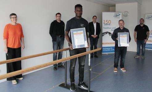 Der Gambier Yusupha Sowe (M.) errang in seinem Ausbildungsberuf Orthopädietechnik-Mechaniker den Kammersieg. Dr. Handirk von Ungern-Sternberg (3.v.r.), Mitglied der Geschäftsleitung der Handwerkskammer Freiburg, und Hanna Böhme (l.), Geschäftsführerin der Freiburg Wirtschaft Touristik und Messe (FWTM), gratulierten ihm. Mike Dehn (2.v.r.), Inhaber des Sanitätshauses Pfänder, der technische Leiter Jochen Adler (2.v.l.) und Ausbilder André Junt (r.) freuten sich mit dem Kammersieger