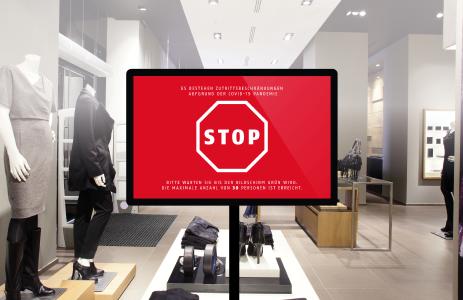 Ein Monitor im Eingangsbereich zeigt anhand eines Ampelsystems dem sich nähernden Kunden, ob er den Laden in diesem Moment betreten darf – oder ob die maximale Kundendichte in der Filiale bereits erreicht ist / Bild: © ABUS