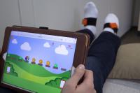 Blick auf das Computerspiel und auf die Sensoren an den Füßen (Foto: TUK)