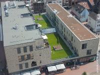Today, the former Hertie department store in Lünen is a modern residential and commercial property with 850 m² of play and sunbathing lawn right in the middle of the roof. Source: GRÜN+DACH / ZinCo