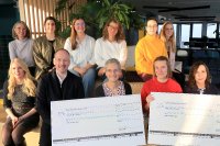 CONET-Mitarbeitende und Mitglieder des CONET Social Club, die Vertreterinnen der Empfängerorganisationen Jungendfarm und AKHD Bonn zusammen mit Director HR Sabine Cox und CONET CEO Martin Wibbe bei der Übergabe der symbolischen Spendenschecks zur CONET-Neujahrsspende 2025.