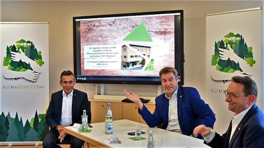 Wegweiser aus der Klimakrise: „Nachhaltig CO2 vermeiden und speichern – mehr Holzbau macht’s möglich!“. Der Bayerische Ministerpräsident Dr. Markus Söder (Mitte) kündigte bei seinem Besuch der Taglieber Holzbau GmbH in Oettingen für Bayern die konsequente Priorisierung des klimaschützenden Bauens mit Holz an. Links Gastgeber Erwin Taglieber, Präsident des Deutschen Holzwirtschaftsrates (DHWR) sowie des Deutschen Holzfertigbau-Verbandes (DHV), rechts Ulrich Lange MdB. (Foto: A. Dathe für den DHV)