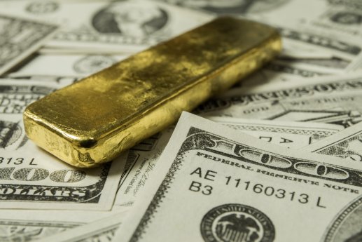 Close up image of Dollar bills with gold bar_Depositphotos_379253544_XL.jpg