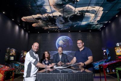 Wie in einer Galaxie fühlen sich die Besucher der Silverball-Lounge beim Betreten des dunklen Raums. Über ihren Köpfen schwebt ein Astronaut durchs All, und auf der gegenüber liegenden Wand geht gerade die Erde auf. Ralf Kaiser, Geschäftsführer der Firma Trobau Wittlich GmbH & Co. KG, wünschte sich ein außergewöhnliches Ambiente für seine kostbare Flippersammlung. Eigens dafür wurde ein neues Deckensystem aus praktisch mit jedem Motiv bedruckbaren Plexiglasplatten mit integrierter dimmbarer Bele