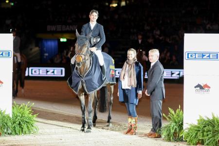 Glückwünsche für das Weltklasse-Paar Venard de Cerisy ist das Gewinnerpferd – nach der Anstrengung geschützt und zugleich geschmückt mit der Siegerdecke in den GEZE Farben. Sandra Alber gratuliert Steve Guerdat zum "Preis der GEZE GmbH" (Bildnachweis: GEZE GmbH)