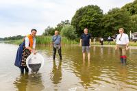 Die 1. Fischerkönigin des Landes Mecklenburg-Vorpommern, Jeannette Dehmel, LAV-Präsident Prof. Dr. Karl-Heinz Brillowski, WEMAG-Vertriebsleiter Michael Hillmann sowie Staatssekretär im Landwirtschaftsministerium Dr. Jürgen Buchwald (v.l.) setzen gemeinsam die Aale in den Goldberger See ein. Foto: WEMAG/Stephan Rudolph-Kramer
