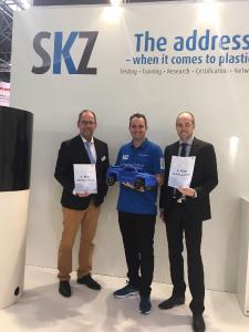 SKZ-Prokurist Dr. Benjamin Baudrit (Mitte) gratuliert Peter Hügen von Sikora (links) und Markus Pest von Coesfeld (rechts) zu ihren Siegen beim Carrera-Rennen mit eigens 3D-gedruckten Fahrzeugen am SKZ-Stand