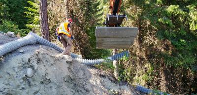 Photo of new screening being placed by Hitachi 180 excavator
