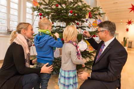 WEMAG-Vorstand Thomas Murche schmückt mit Kindern und Carolin Schulz vom Demmlerhaus (v.re.) den Weihnachtsbaum mit Wünschen. Foto: WEMAG/Stephan Rudolph-Kramer
