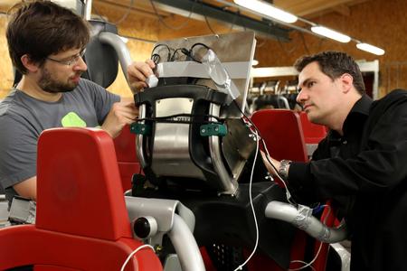Prof. Thomas Wagner (rechts) und der Lehrbeauftragte Michael Heyse (links) montieren ein Laptop an einem Sitzplatz der Achterbahn "Blue Fire"