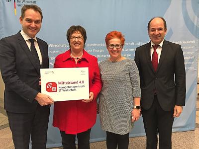 Bundeswirtschaftsministerin Brigitte Zypries überreicht dem BITMi-Vorstand Oliver Grün (links), Andera Gadeib (2. v. r.) und Martin Hubschneider (rechts) den Bescheid für das Mittelstand 4.0-Kompetenzzentrum IT-Wirtschaft