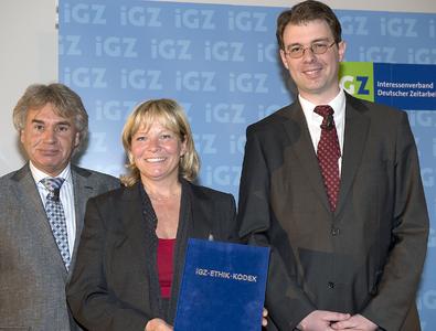 Werner Stolz (l.) und Martin Dreyer überreichten Ariane Durian den iGZ-Ethik-Kodex in blauem Samtumschlag