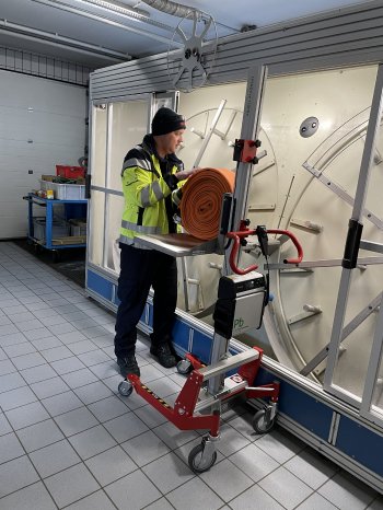 PRONOMIC_Feuerwehr_Hebelift_ergonomisches Schlauchhandling_Feuerwehrmann_gerollter Schlauch wird.jpg