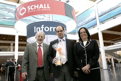 Paul E. Schall (l.) und seine Frau Bettina Schall (r.), beide Geschäftsführer der P. E. Schall GmbH und Co. KG, ehren den 500.000sten Messebesucher Kornel Barna (Mitte)
