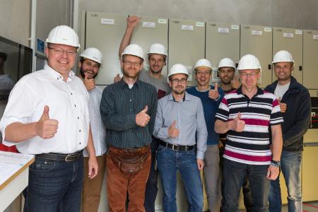 Freuen sich im Batteriespeicher über den Erfolg der Phase 1: WEMAG-Projektkoordinator Tobias Struck (li) mit seinem Team sowie den Mitarbeitern von Younicos und der Universität Rostock. Foto: WEMAG/Stephan Rudolph-Kramer