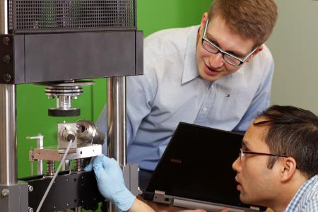 Die Kaiserslauterer Ingenieure Nicholas Ecke (li.) und sein Kollege Dong Hoa Vu untersuchen die Eigenschaften ihrer Kunststoffe an einer Prüfmaschine, dem Stift-Scheibe-Tribometer (Foto: TUK/Thomas Koziel)