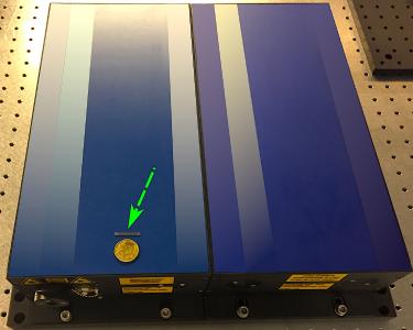 The green arrow points to a chip that can be equipped with up to ten femtosecond lasers. The blue box on which it rests, on the other hand, is a single conventional laser. Picture: CFEL / Neetesh Singh