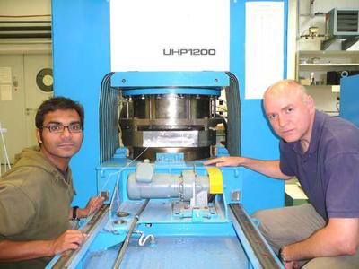 Dr. Shantanu Keshav (links) und Dr. Gundmundur Gudfinnsson vor einer Vielstempel-Presse des Bayerischen Geoinstituts, mit der die Hochdruck- und Hochtemperaturbedingungen im tiefen Erdinneren im Labor simuliert werden