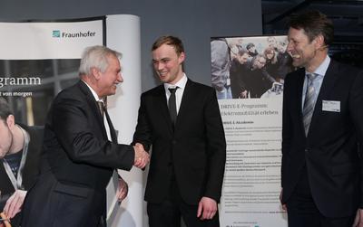 Die Verleihung der DRIVE-E-Studienpreise 2013: Prof. Dr. Ulrich Buller, damaliger Vorstand Forschungsplanung der Fraunhofer-Gesellschaft, gratuliert Preisträger Stephan Leppler von der TU Berlin. Rechts Dr. Georg Schütte, Staatssekretär im BMBF