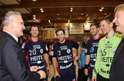 Joachim Herrmann, Bayerische Staatsminister und Aufsichtsrat des HC Erlangen, gratuliert den Spielern zum bravourösen Sieg (Foto: hl-studios)