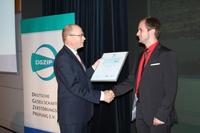 Prof. Gerhard Mook, Kuratoriumsvorsitzender Nachwuchspreis, übergibt René Böttcher die Ehrenurkunde, Foto: © DGZfP/Friederike Pohlmann