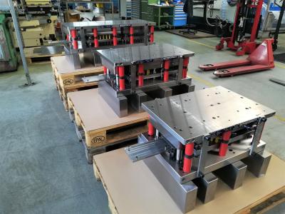Drei Folgeverbundwerkzeuge zur Herstellung von Lichtschalterrahmen aus Aluminium.