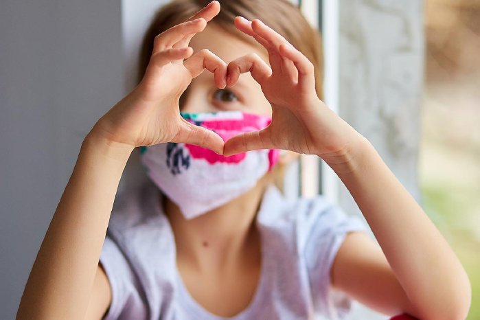 little-girl-child-in-mask-making-hearts-from-hands-F3FL2P6.jpg