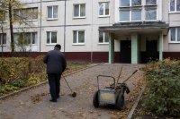 Hausmeister kehrt am Morgen den Zugang eines Mehrfamilienhauses