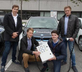 Das Studententeam der Hochschule Darmstadt vor LBF-Forschungsfahrzeugen und der Ladesäule des Fraunhofer LBF, Foto: Fraunhofer LBF