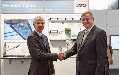 Presentation of the LED machine lights at Hannover Messe 2013: Wolfgang Keller (left), Head of the Optoelectronic Systems business unit, and Martin Müller, Head of the I/O and Networks business unit at Phoenix Contact Electronics, showcase the result of their collaboration