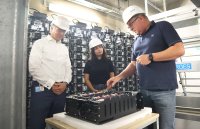 WEMAG-Vorstand Thomas Murche (li.) und der Batteriespeicher-Geschäftsführer Tobias Struck erklären Reem Alabali-Radovan, Bundestagsabgeordnete und Staatsministerin beim Bundeskanzler, die Funktionsweise des Batteriespeichers.