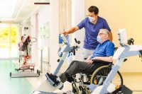 Beim therapeutischen Training - Johannes Danke, Fachkompetenzleitung Physiotherapie weist einen Patienten in das Training ein. 40 motorbetriebene THERA-Trainer der neuesten Generation an Bewegungstrainern kommen an allen sechs Standorten der Kliniken Schmieder