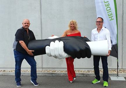 Das Foto zeigt (v. l.) Rolf Stahlhofen von der „WaterIsRight“-Foundation (WIR), Designerin Claudia Bias und Unternehmer Matthias Blatz mit der „GEMEINSAM BEWEGEN“-Skulptur, die zugunsten der WIR-Stiftung versteigert wird. Foto: Heidelberg iT